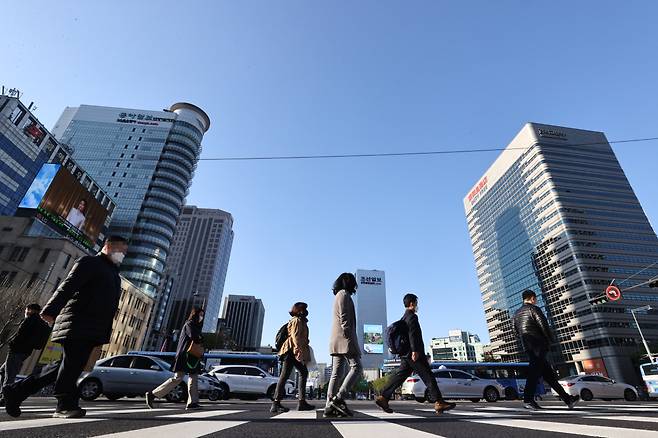 Pedestrians walk across a street near Gwanghwamun Square in central Seoul. (Yonhap)