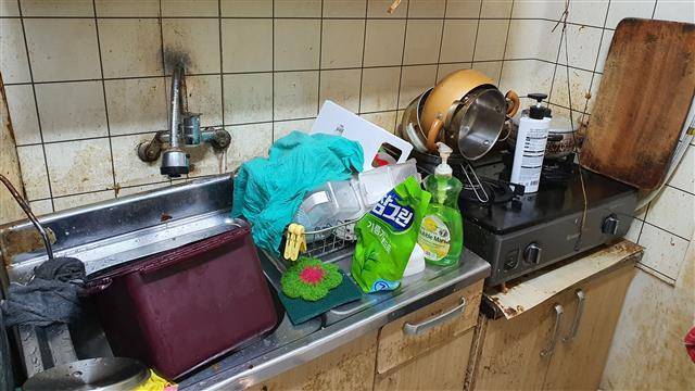 용산2가동 주민센터가 지난 11일 김칠수(가명) 노인의 쓰레기집 청소에 나섰다. 청소 전 김 노인의 집 싱크대 모습.