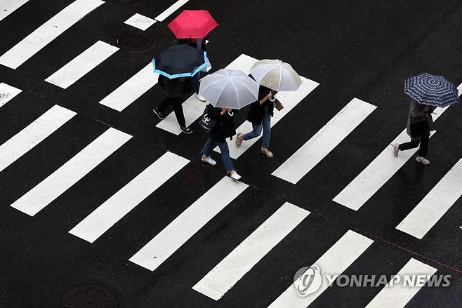 가을비 굵은 빗방울을 뿌리는 비구름이 해를 가려 잔뜩 흐린 날씨를 보인 지난 7일 오전 서울 중구 거리에서 우산을 쓴 시민들이 길을 걷고 있다. [연합뉴스 자료사진]