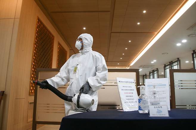 서울 여의도 국회 본청 건물에서 방역 관계자가 소독 작업을 하고 있는 모습 [연합]