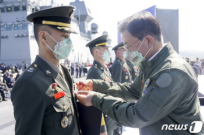 문재인 대통령이 1일 경북 포항 영일만 해상 마라도함에서 열린 제73주년 국군의 날 기념식에서 김정수 소령에게 화랑무공훈장을 수여하고 있다.2021.10.1/뉴스1 © News1 이광호 기자