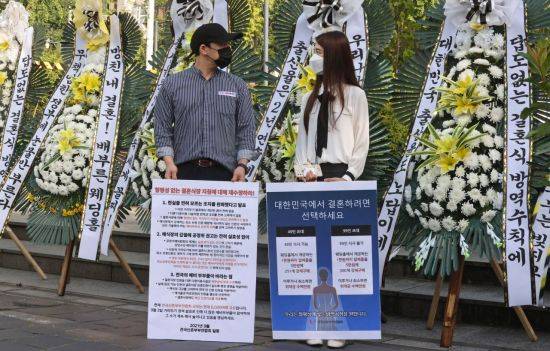 지난달 9일 오전 정부서울청사 앞에서 전국신혼부부연합회 회원들이 정부의 결혼식 방역 지침 개선을 요구하며 화환 시위를 하고 있다. [이미지출처=연합뉴스]