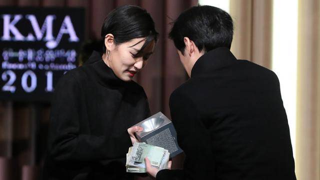 가수 이랑(왼쪽)이 2017년 한국대중음악상 시상식에서 받은 '최우수 포크 노래상' 트로피를 현장에서 경매로 팔고, 그걸 산 관객과 트로피와 현금을 주고 받고 있다. 이랑은 "이것으로 돈과 명예를 모두 얻었다"고 말했다. 아티스트로서 예술과 생활의 공존의 절박함을 보여주기 위한 퍼포먼스였다. 연합뉴스