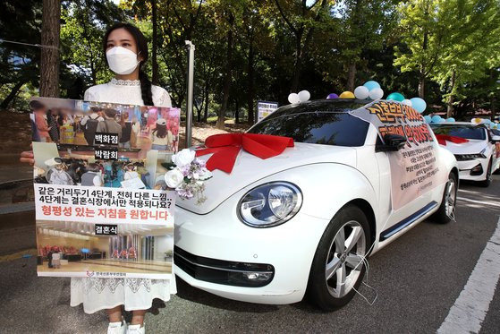 전국신혼부부연합회가 9월 15일 오전 서울 영등포구 한국방송공사 앞 공영주차장에서 정부의 결혼식장 방역 지침 개선을 요구하며 웨딩카 주차 시위를 진행했다. 중앙포토