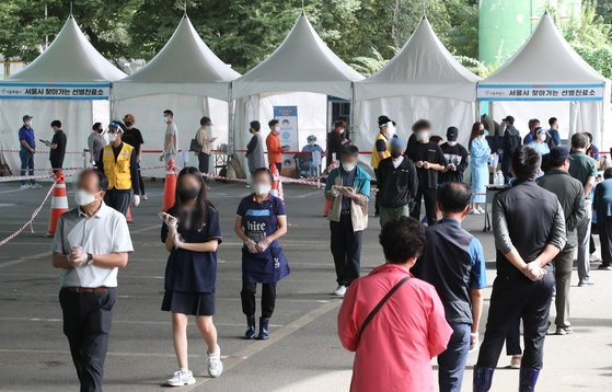 지난달 30일 오전 서울 송파구 가락시장 '서울시 찾아가는 선별진료소'에서 검사를 받으려는 시민들이 줄을 서 있다.   연합뉴스