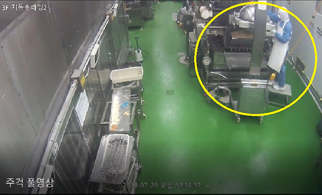 '던킨 위생 불량' 제보 영상 촬영자로 보이는 직원이 설비 외부에서 고무주걱으로 기름을 긁어내는 것으로 보이는 장면. / 사진=비알코리아 제공