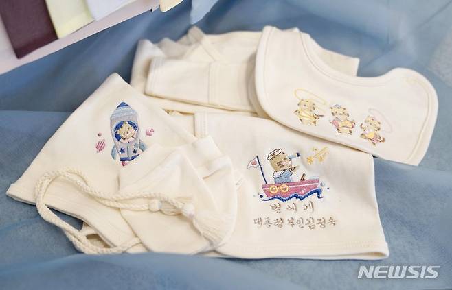 [포항=뉴시스] 김진아 기자 = 김정숙 여사가 국군의 날인 1일 오후 경북 포항 해병대1사단 부대에서 열린 장병 격려 오찬 참석자 중 셋째 자녀 임신 소식을 알린 한 해병 대위에게 태명을 수놓은 배냇저고리를 선물하고 있다. 사진은 김 여사가 선물한 배냇저고리와 축하카드 모습. 2021.10.01. bluesoda@newsis.com