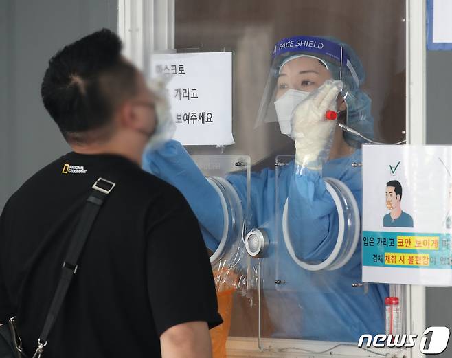 1일 오전 서울 중구 서울역 앞 신종 코로나바이러스 감염증(코로나19) 임시선별검사소에서 의료진이 검체 검사를 하고 있다. 중앙방역대책본부는 1일 0시 기준 코로나19 신규 확진자가 2486명이라고 밝혔다. 이날 신규 확진자의 감염 경로는 국내 발생 2451명, 해외유입 35명이다. 2021.10.1/뉴스1 © News1 송원영 기자
