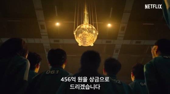 ‘돈이 전부인 세상’을 암시하기 위해 돈다발이 떨어지는 투명 돼지저금통을 세트 천장 높이 매달았다. [사진 넷플릭스]