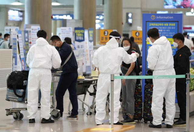 23일 인천국제공항 제1터미널에서 해외입국자들이 방역 관계자들의 안내를 받고 있다. 영종도=연합뉴스