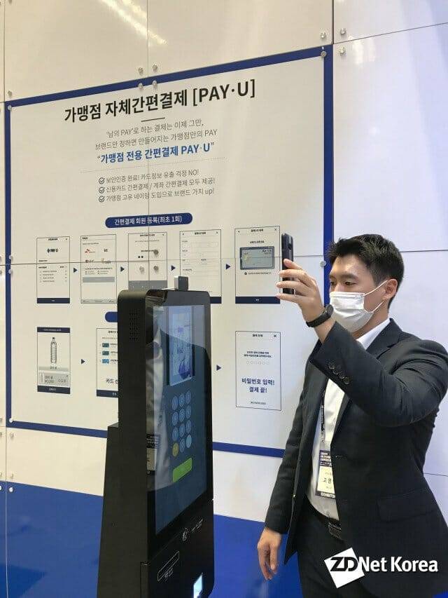 NICE페이먼츠 관계자가 6일 서울 삼성동 코엑스에서 열린 ‘대한민국 4차 산업혁명 페스티벌’에서 휴대전화 사진으로 안면인증 결제가 되는지 시험하고 있다.(사진=유혜진 기자)