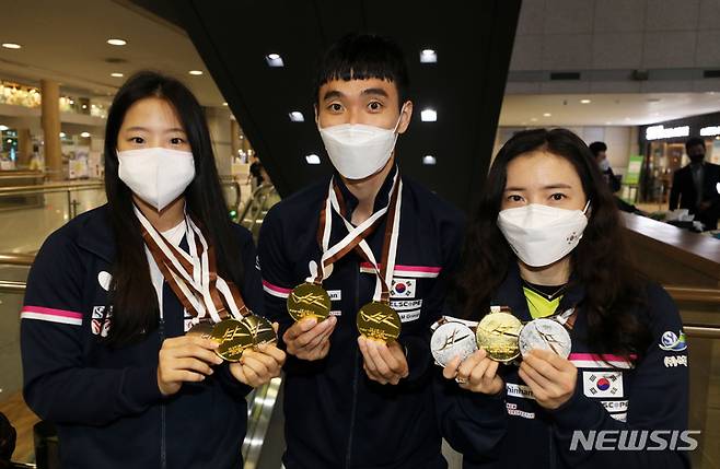 [인천공항=뉴시스] 고범준 기자 = 카타르 도하에서 열린 2021 ITTF-ATTU 아시아탁구선수권 남자 단식 결승에서 금메달을 획득한 이상수, 여자 복식 결승에서 금메달을 획득한 전지희와 신유빈이 6일 오후 인천국제공항 제1터미널을 통해 귀국해 메달을 들고 포즈를 취하고 있다. 2021.10.06. bjko@newsis.com