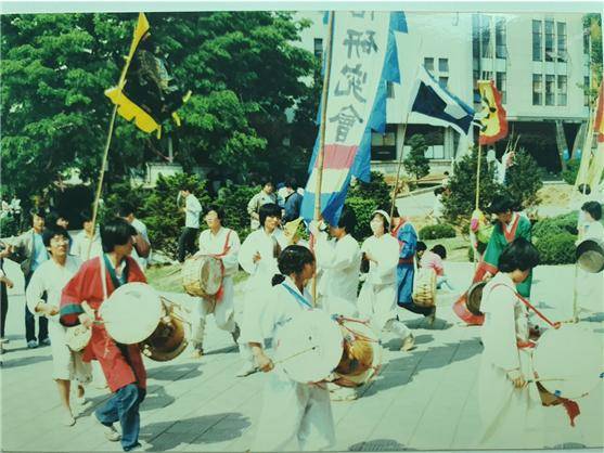 ▲88년 10월 송파산대놀이 공연 사진 1 – 본공연에 앞서 문과대 앞에서 길놀이 진행 중이다. 쇠 잡은 이가 상쇠 86학번 회장 이영식, 부쇠가 86학번 박혜란, 징잽이 87학번 류탁균, 그 뒤로 88학번 조난주, 87학번 이정선, 필자가 장구를 잡고 있고 87학번 회장 양희조와 87학번 김학준이 북을 잡고 있다. ⓒ마승락
