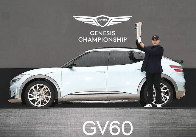 2021 제네시스 챔피언십 우승자 이재경 선수가 GV60과 함께 포즈를 취하고 있다.