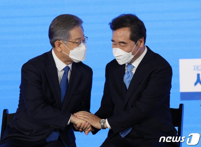 더불어민주당 제20대 대통령선거 후보에 선출된 이재명 경기지사가 10일 오후 서울 송파구 올림픽공원 SK올림픽핸드볼경기장에서 열린 서울 지역 경선 및 3차 국민선거인단 투표에서 최종 후보 선출 발표를 들을 후 이낙연 전 대표에게 축하를 받고 있다. 2021.10.10/뉴스1 (C) News1 국회사진취재단