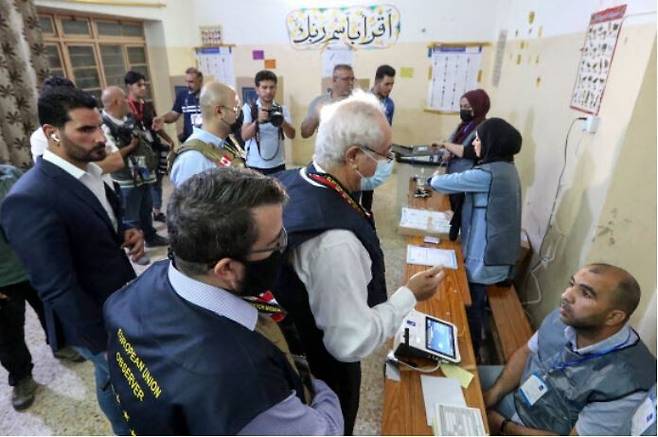 10일 총선이 실시된 이라크 수도 바그다드의 한 투표소에서 유럽연합의 선거참관단들이 개표를 진행하는 선관위 직원들과 대화하고 있다. 바그다드/AFP 연합뉴스