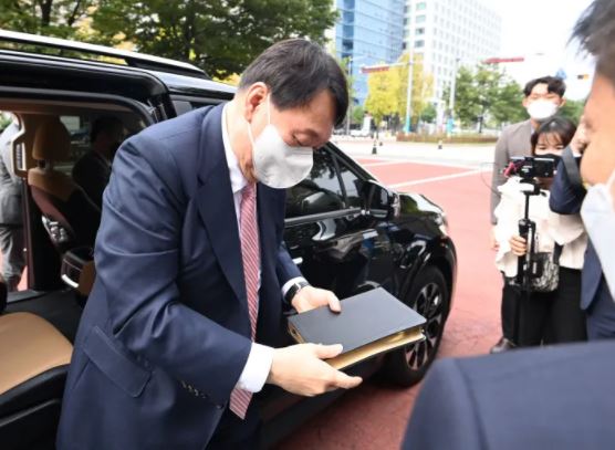 Former Prosecutor General Yoon Seok-youl, a presidential candidate of the People Power Party, gets out of the car holding a Bible to attend a religious service at Yoido Full Gospel Church in Seoul on October 10. National Assembly press photographers