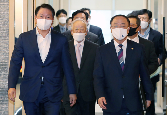 Chey Tae-won, chairman of the Korea Chamber of Commerce and Industry (KCCI), left, enters a conference room at the KCCI in central Seoul with Finance Minister Hong Nam Ki on Oct. 8. [YONHAP]