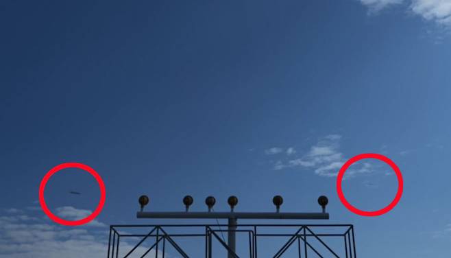 지난 10일 오후 2시26분께 부산 김해공항 인근에서 확인되지 않은 물체가 하늘을 가로지르고 있다. 작은 물체 2개가 비행기보다 훨씬 빠른 속도로 날아가는 장면이 우연히 카메라에 포착됐다. [연합]