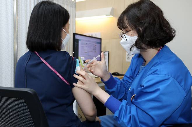 코로나19 치료병원 종사자들에 대한 추가접종(부스터샷)이 시작된 12일 서울 국립중앙의료원에서 의료진이 백신 접종을 받고 있다.  사진공동취재단