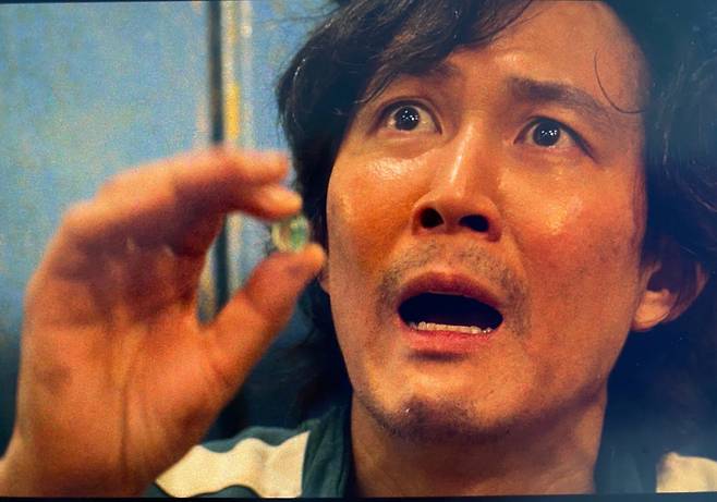 ‘오징어게임’에서 이정재(극중 성기훈)가 마지막 남은 구슬 하나를 들어 보이고 있다 [넷플릭스]