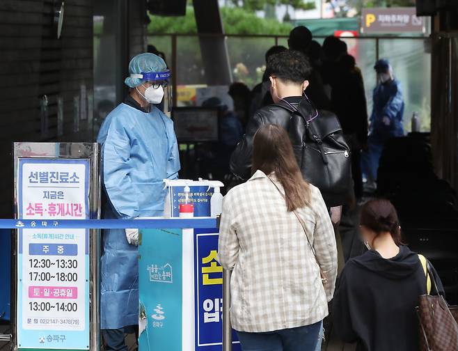 12일 서울 송파구 보건소 선별진료소에서 시민들이 신종 코로나바이러스 감염증(코로나19) 검사를 기다리고 있다. [연합]