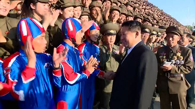 지난달 9일 열병식에서 김정은 북한 국무위원장이 기념촬영에 앞서 낙하산병과 악수를 하고 있다./조선중앙통신 연합뉴스