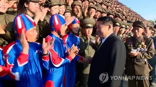 북한 김정은 국무위원장이 북한 정권수립 73주년인 지난달 9일 자정에 열렸던 열병식 참가자들과 기념사진을 촬영했다고 조선중앙TV가 진난달 10일 보도했다. 김 위원장이 기념촬영에 앞서 낙하산병과 악수를 하고 있다. [조선중앙TV 화면]