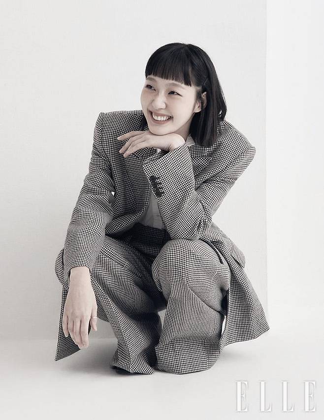 체크 팬츠 수트는 Juun.J. 프릴 장식의 화이트 블라우스는 Soeur. 골드 링은 모두 배우 소장품.