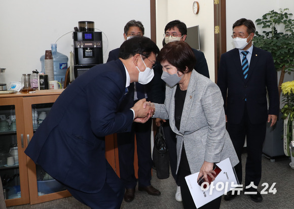 더불어민주당 대선 경선에서 불거진 '무효표 논란'과 관련해  '결선 투표'를 주장하는 이낙연 후보 측의 이의제기로 13일 오후 국회에서 열린 당무위원회의가 종료된 후 송영길 대표가 회의를 마치고 나오는 전혜숙 최고위원의 손을 잡으며 인사하고 있다.