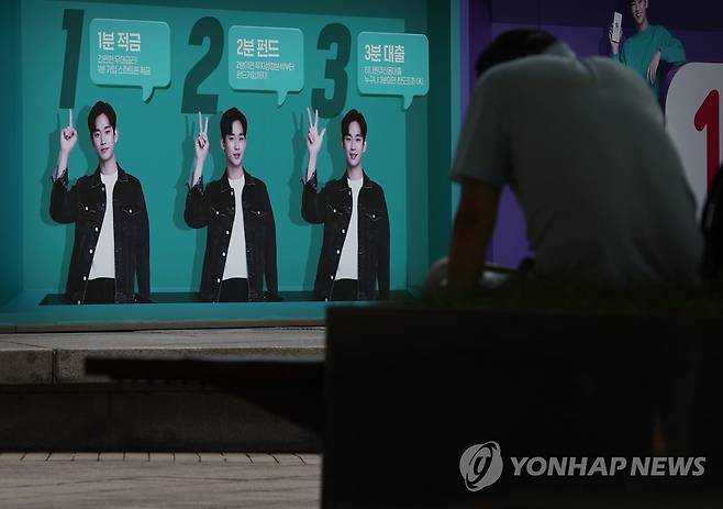 가계대출 1천700조 8월 20일 서울시내 한 은행에 내걸린 대출 등 은행 금융상품 광고판 앞에서 한 시민이 휴식을 취하는 모습 [연합뉴스 자료사진]