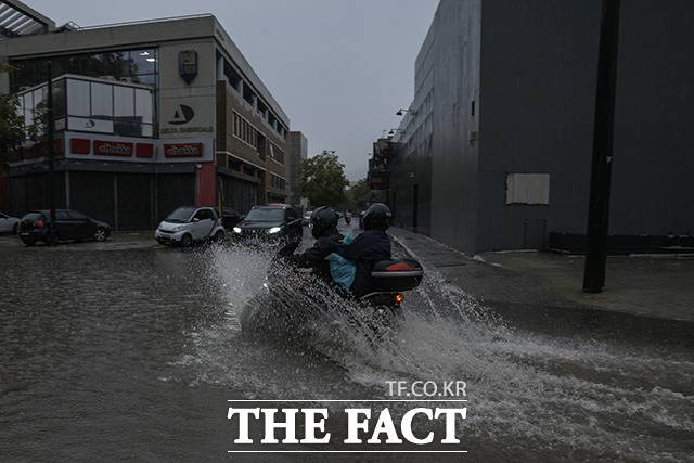 침수된 도로에서 힘겹게 이동하는 오토바이와 차량들. / 아테네=AP.뉴시스