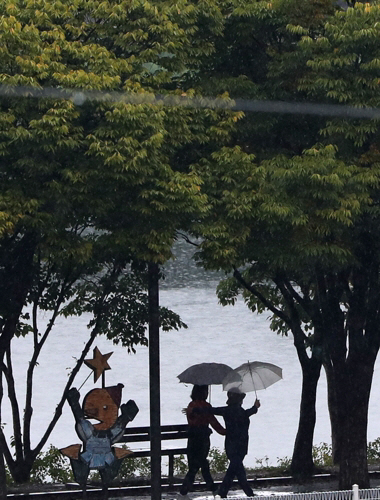 수도권을 제외한 전 지역에 비 소식이 예보된 15일 강원 춘천시 공지천 산책로에서 우산을 쓴 시민이 발걸음을 옮기고 있다. [사진 = 연합뉴스]