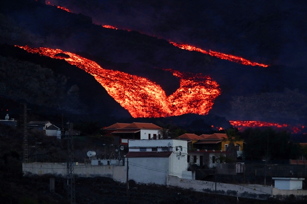 13일 스페인령 카나리아제도 라팔마섬 쿰브레 비에하 화산에서 쏟아진 용암이 로스 야노스 지역 주택가를 덮치고 있다./로이터 연합뉴스