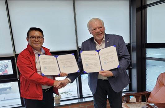 장현식 코리아하이테크 대표(사진 왼쪽)와 닐스 스베닝슨 노마코 댄마크 A/S 기술담당이 유럽형 농업용 동력 운반차 개발을 위한 업무 협약을 맺고 기념촬영했다.