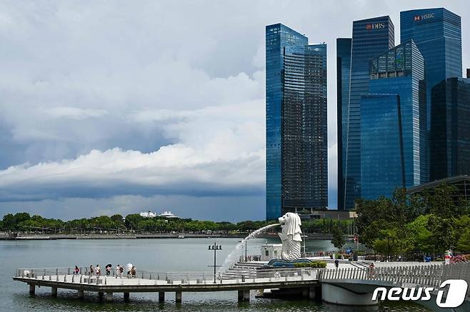 People stand along the pier next to the Merlion statue in Singapore on August 16, 2021. (Photo by Roslan RAHMAN / AFP) © AFP=뉴스1
