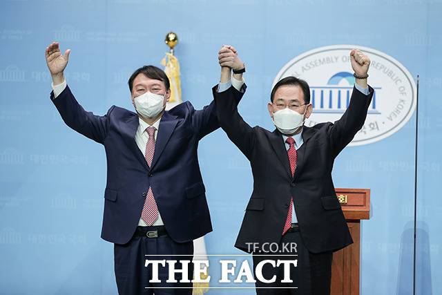 국민의힘 대선 주자인 윤석열 전 검찰총장(왼쪽)이 17일 오전 서울 여의도 국회 소통관에서 열린 주호영 의원 영입 기자회견에서 손을 맞잡고 기념촬영을 하고 있다. /윤석열 캠프 제공