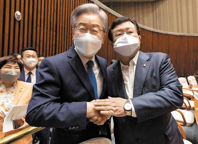 더불어민주당 이재명(왼쪽) 대선 후보가 15일 서울 국회에서 열린 민주당 의원총회에서 이낙연 전 대표 측 공동 선거대책위원장이었던 설훈 의원을 만나 악수하고 있다. 이 후보는 이날 “이 전 대표의 품격과 품 넓음에 진심으로 감동했다”고 했다. /이재명 캠프