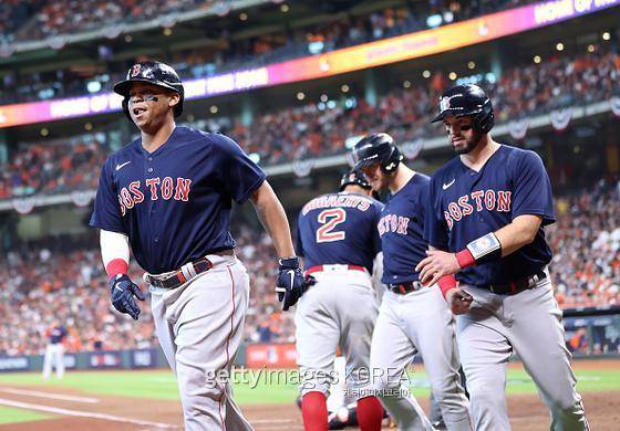 보스턴 3루수 라파엘 데버스(왼쪽)가 17일(한국시간) 미국 텍사스주 휴스턴의 미닛메이드 파크에서 열린 메이저리그 아메리칸리그 챔피언십 시리즈 2차전에서 2회 초 만루 홈런을 치고 동료들과 함께 들어오고 있다. 사진=게티이미지