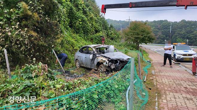 충북 청주시 상당구 산성입구 교차로 인근에서 지난 15일 전복사고로 전소된 차량을 관계자들이 수습하고 있다. 이삭 기자