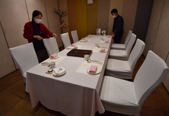 8인 테이블 준비하는 식당 - 17일 서울 서초구 한 한식당에서 직원들이 8인 테이블을 준비하고 있다. 단계적 일상 회복 전 마지막 조정으로 18일부터 적용되는 사회적 거리두기에 따라 수도권 등 4단계 지역도 시간 관계없이 백신 접종 완료자 4명을 포함한 8명까지 사적 모임이 가능하다.박지환 기자 popocar@seoul.co.kr
