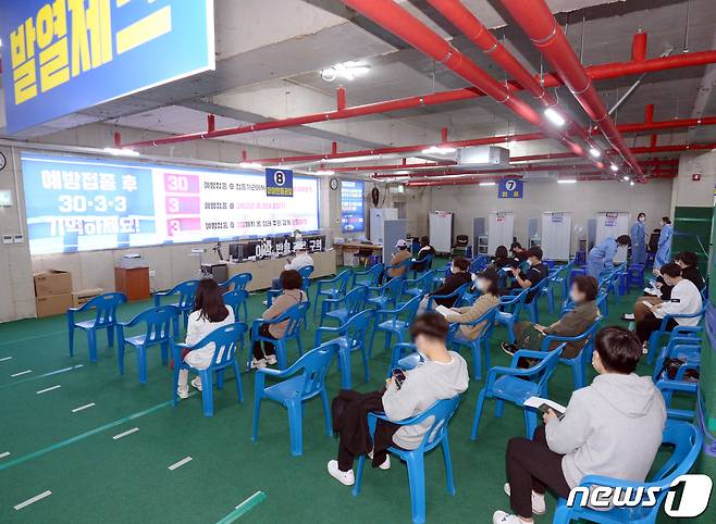 임산부와 16~17세 청소년 대상 신종 코로나바이러스 감염증(코로나19) 백신 접종이 시작된 18일 오전 광주 북구 두암동 한 병원에서 시민들이 백신접종 후 이상반응 관찰을 위해 좌석에 앉아있다. 2021.10.18/뉴스1 © News1 정다움 기자