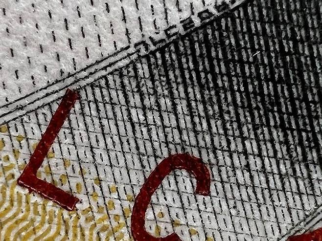 망원 사진의 접사 기능으로 사진을 촬영한 뒤 해상도만 줄인 예시. 해당 사진은 5만 원권에 그려진 신사임당의 옷깃에 있는 위조방지용 글자다. 출처=IT동아