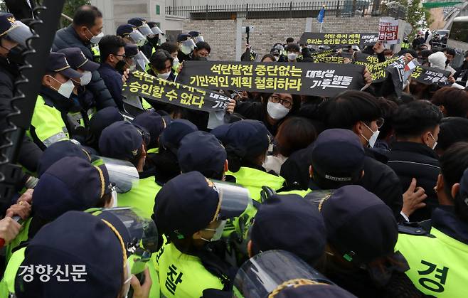 환경단체 “더 감축하라” 기습시위 문재인 대통령이 참석한 탄소중립위원회 전체회의가 열린 18일 서울 용산구 노들섬 다목적홀 인근에서 대학생기후행동 등 환경단체 회원들이 ‘감축 시나리오 전면 재수립’ 등을 요구하는 기습시위를 벌이다 경찰에 의해 제지당하고 있다. 권도현 기자 lightroad@kyunghyang.com