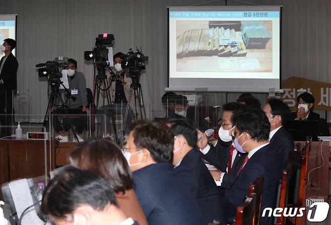 국민의힘이 18일 오후 경기도 수원시 팔달구 경기도청에서 열린 국회 행정안전위원회의 경기도 대한 국정감사에서 더불어민주당 대선후보인 이재명 경기도지사의 '조폭 연루설'을 주장하며 관련 돈다발 사진을 공개하고 있다. 2021.10.18/뉴스1 © News1 김영운 기자