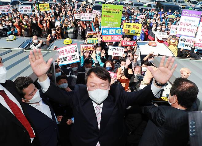 국민의힘 윤석열 대선 경선 후보가 19일 부산 연제구 부산개인택시조합을 찾아 택시 기사들과 간담회에 앞서 두 손을 들어 지지를 호소하고 있다. 연합뉴스