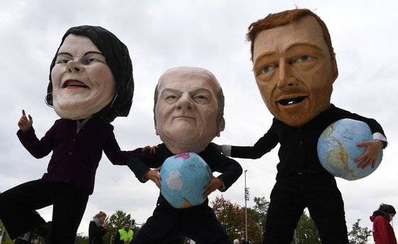 지난 15일 독일의 환경운동가들이 녹색당 대표인 아날레나 베어보크, 사민당의 올라프 숄츠 대표, 자유민주당 크리스티안 린드너 대표(왼쪽부터)의 얼굴을 본뜬 가면을 착용한채 거리를 걷고 있다. 연합뉴스