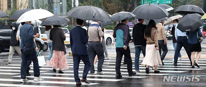 [서울=뉴시스] 이영환 기자 = 가을비가 내리고 있는 8일 오후 서울 종로구 광화문네거리에서 시민들이 우산을 쓰고 걸어가고 있다. 2021.10.08. 20hwan@newsis.com