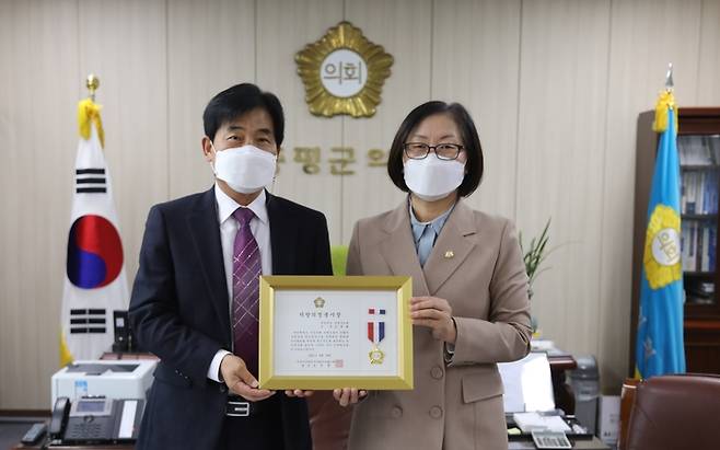 [증평=뉴시스] 강신욱 기자 = 충북 증평군의회 조문화(오른쪽) 의원이 전국시군자치구의회의장협의회가 수여하는 의정봉사상을 연풍희 증평군의회의장으로부터 전수받고 있다. (사진=증평군의회 제공) 2021.10.19. photo@newsis.com *재판매 및 DB 금지