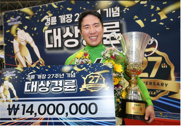 경륜개장 27주년 기념 대상경륜 시상식에서 우승자 임채빈 선수가 트로피를 받고 활짝 웃고 있다. 임 선수는 ‘선행 작전이 주요했다’ ‘고객들과 빨리 만나고 싶다’ ‘우승해서 기쁘다’는 소감을 밝혔다.
